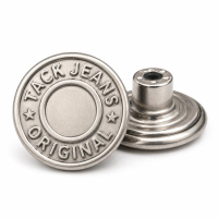 Professional-grade silver metal jeans button with "Tack Jeans Original" circular branding for high-end denim apparel production.