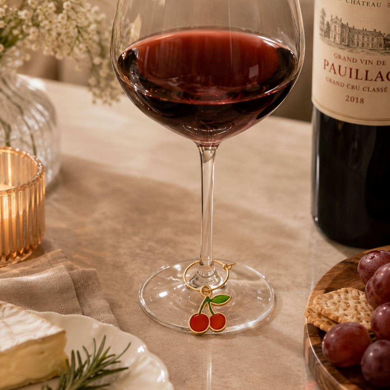 Custom cherry-shaped wine glass charm attached to a wine glass stem, featuring soft enamel colors and gold-plated metal finish for weddings, wineries, parties, and promotional events.