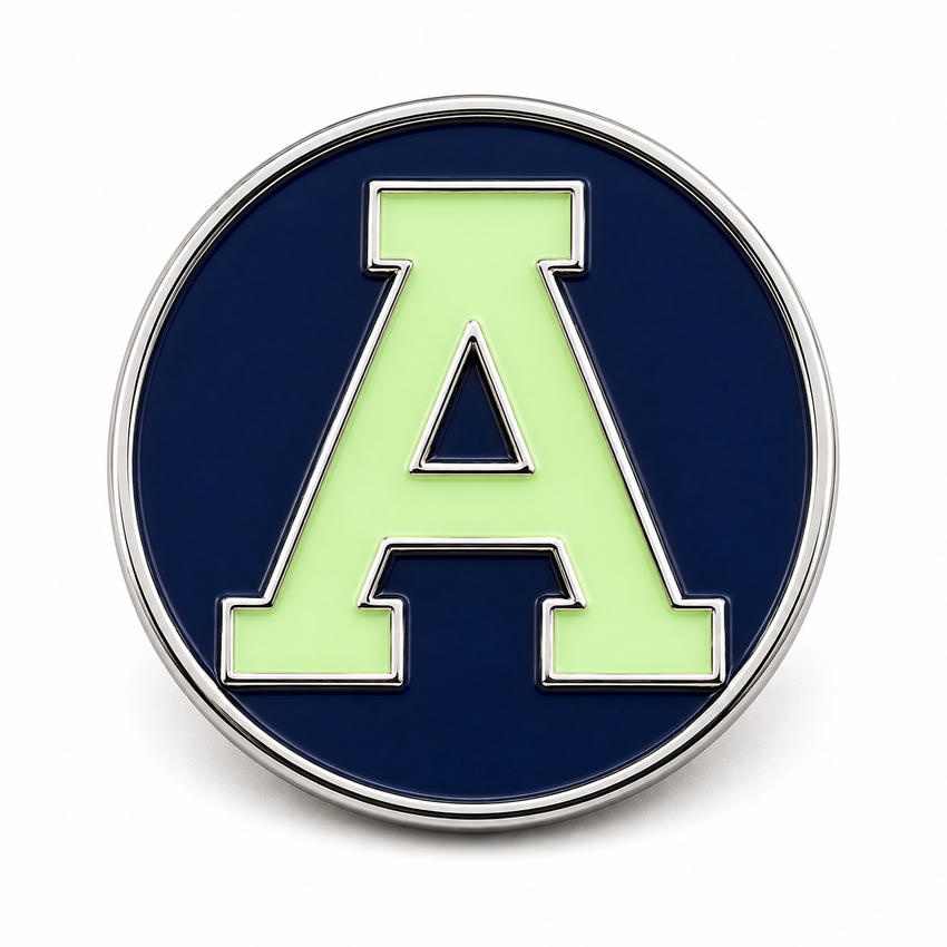 Custom Luminous Logo Letter Enamel Pin Round logo enamel pin with silver metal border, navy background, and luminous green letter A.